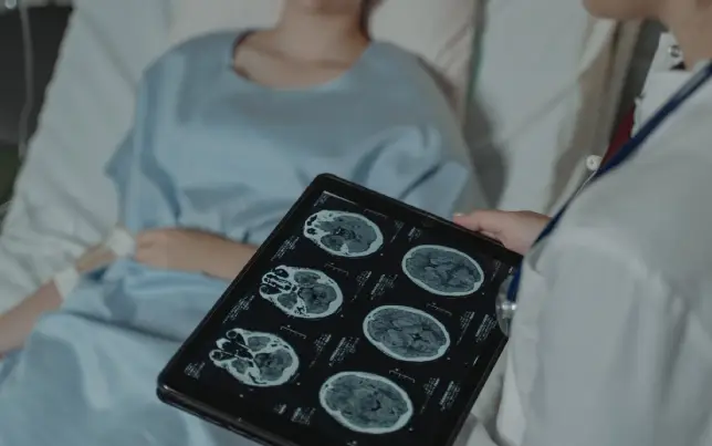 Doctora leyendo una TC de cerebro en una tablet.